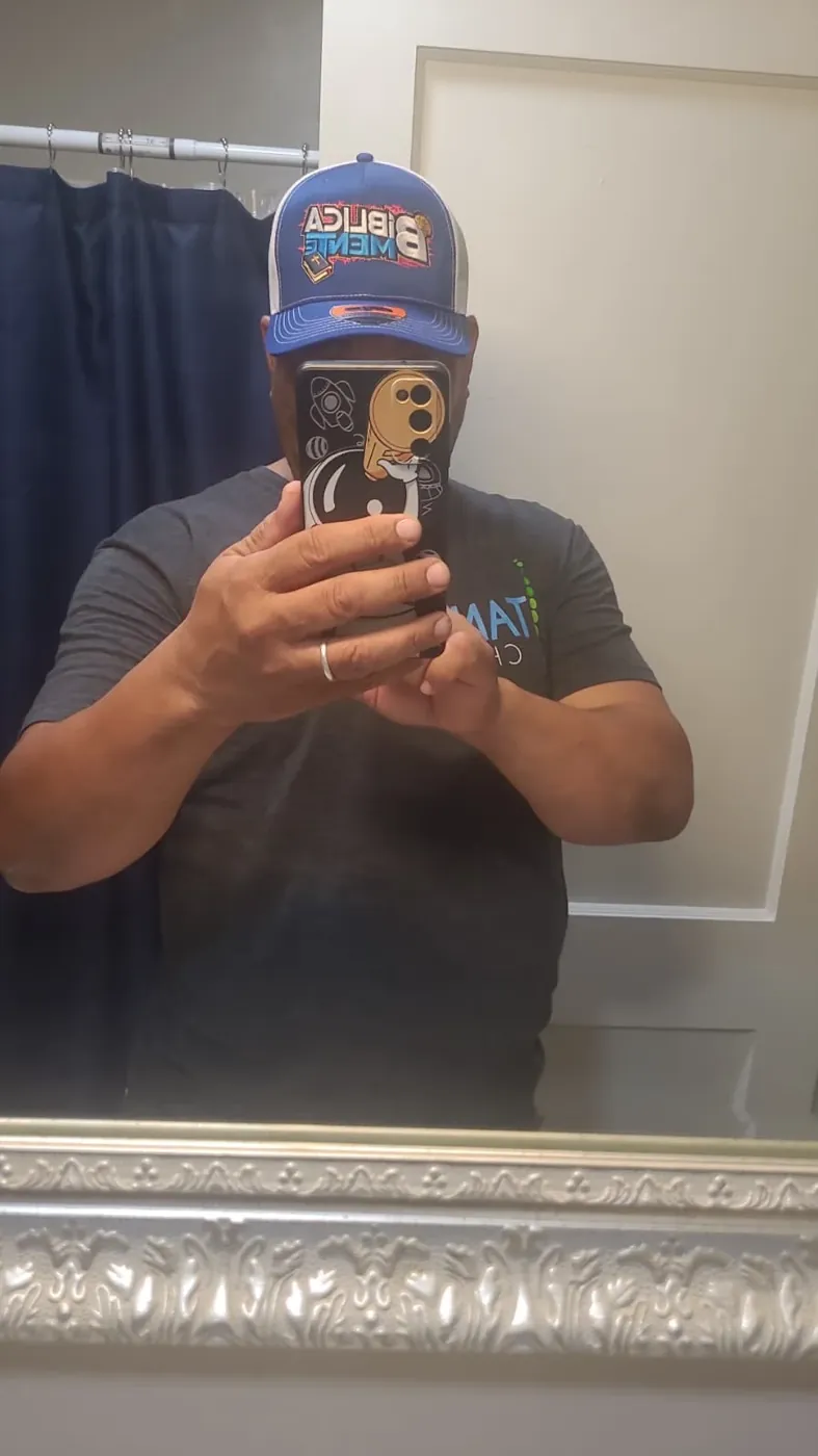 Customer wearing a royal blue and white trucker cap with a colorful embroidered logo